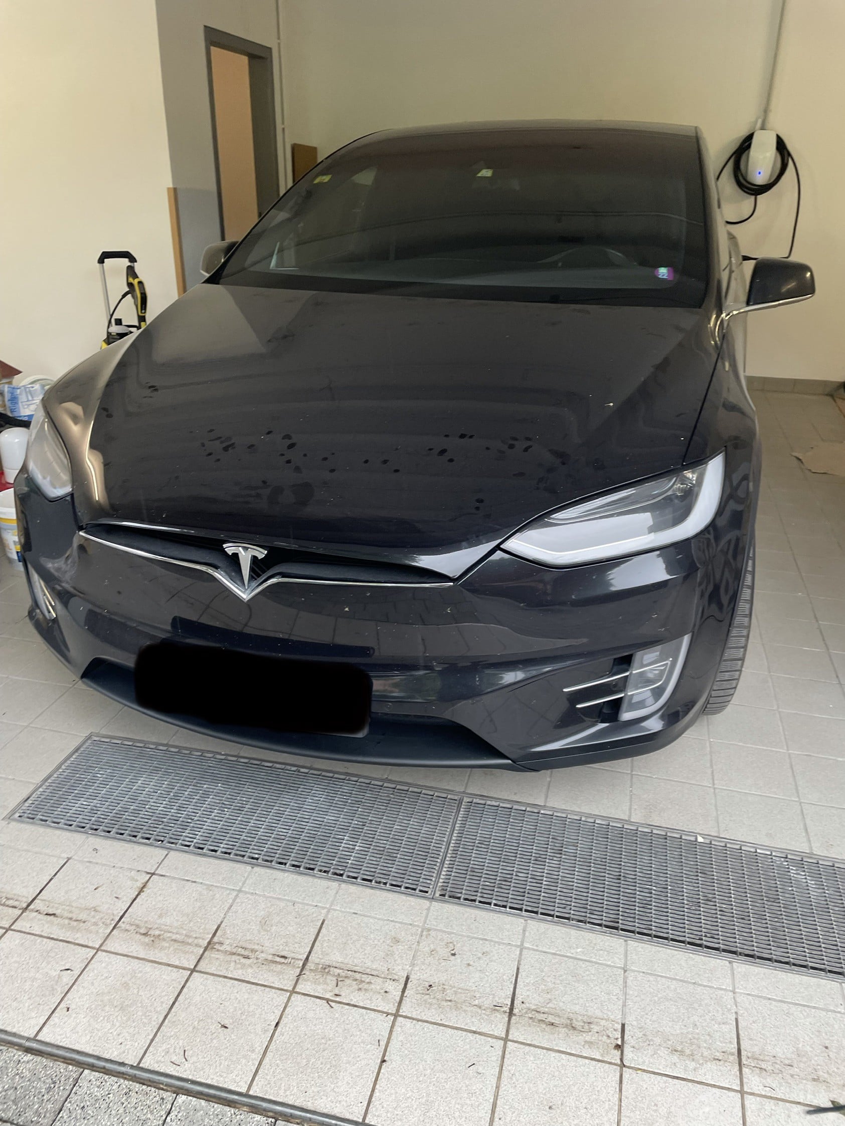 Elektromobil Tesla v garáži rodinného domu v Rovinke s nástenným wallboxom na domáce nabíjanie.