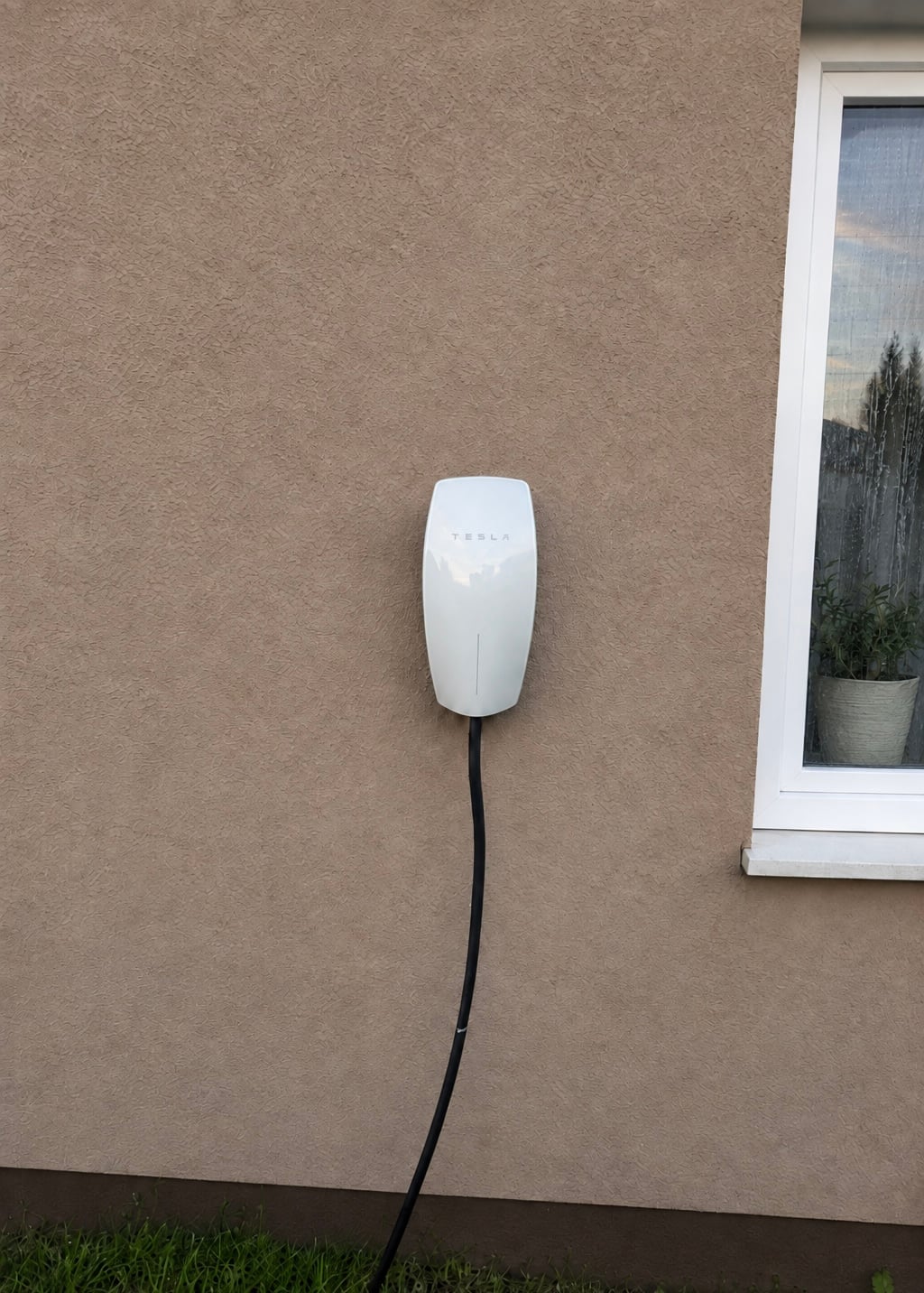 Inštalácia nabíjacej stanice Tesla Wall Connector na hnedej fasáde rodinného domu v Nitre