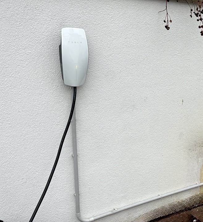 Tesla Wall Connector na fasáde rodinného domu v Zálesí – domáca nabíjacia stanica pre elektromobil.