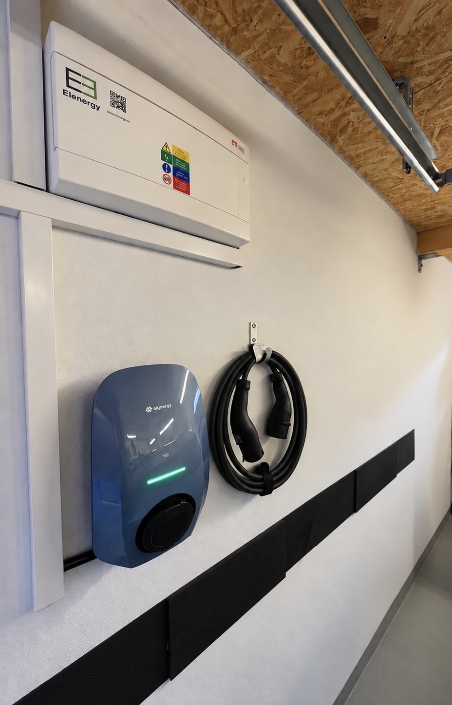 Nástenný wallbox  v garáži v Senci s nabíjacím káblom uloženým na držiaku.