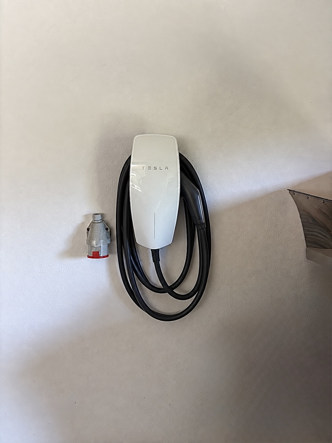 Tesla Wall Connector Gen 3 s navinutým nabíjacím káblom namontovaný na stene v Bratislave – realizácia ELMS Group